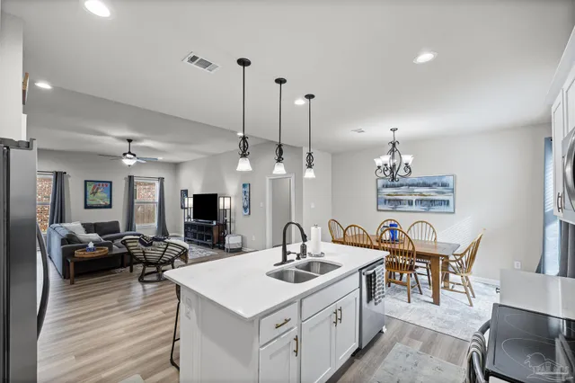 a kitchen with stainless steel appliances a stove center island a large window and chairs