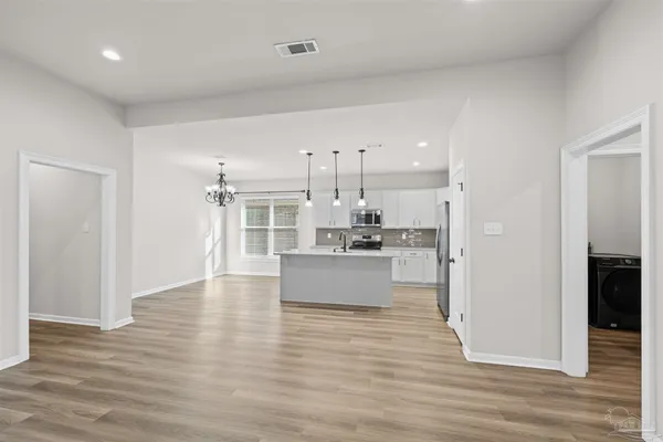 a kitchen with stainless steel appliances kitchen island granite countertop a stove top oven a sink with wooden floors