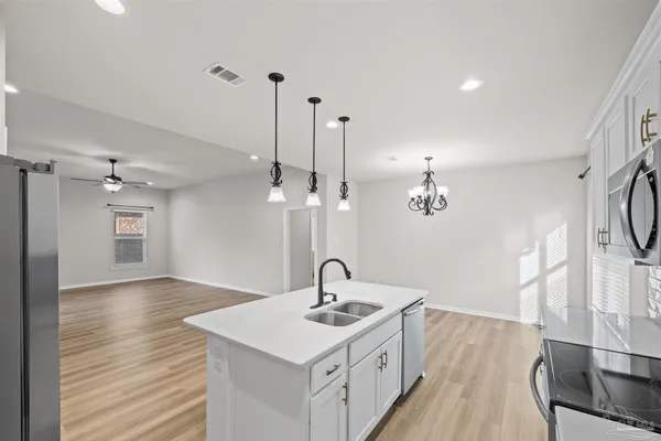a kitchen with stainless steel appliances granite countertop a sink a stove and a refrigerator