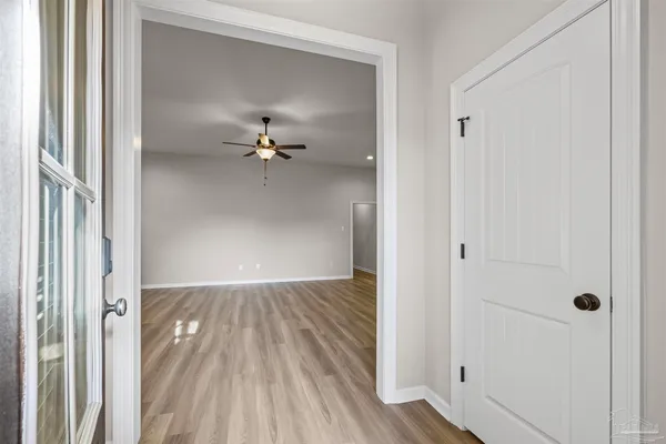 a view of an empty room with wooden floor and a window