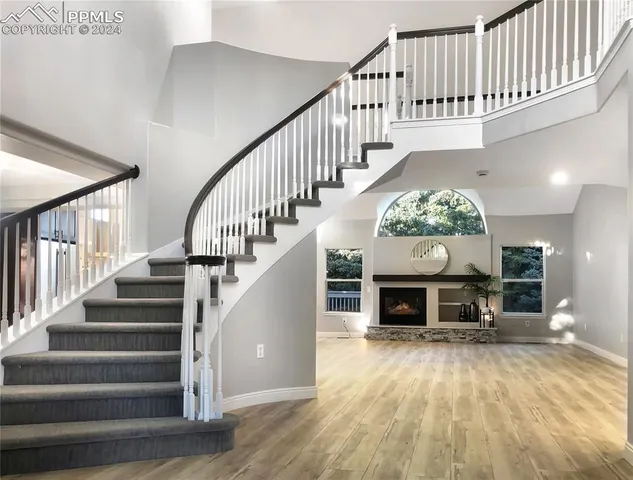 a view of a hallway with wooden floor a fireplace and entryway