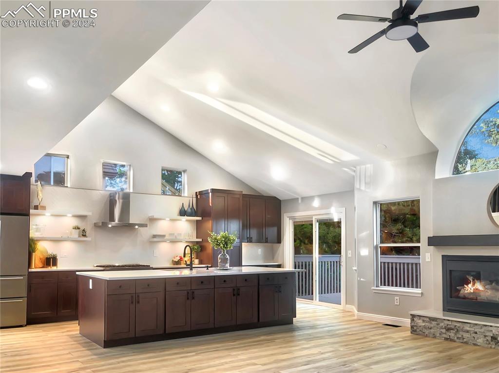 7873 Sweet Water Road Lone Tree, CO 80124 - Photo 6 of 48 a living room with stainless steel appliances kitchen island granite countertop a table chairs refrigerator and a fireplace