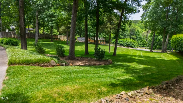 an aerial view of residential house with outdoor space and trees all around