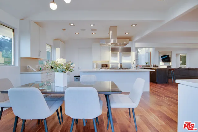 a dining room with furniture and a potted plant