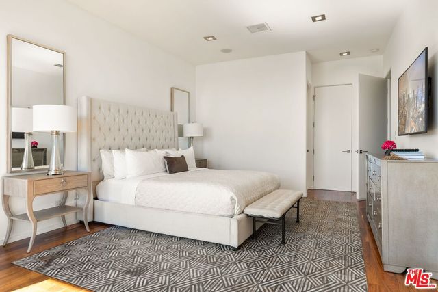 a large bedroom with a bed and a large window