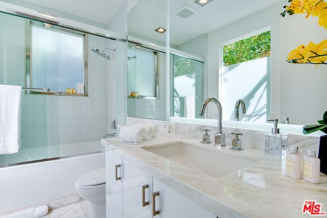 a bedroom with a large bed and a potted plant