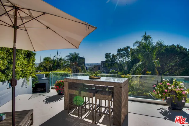a view of a patio with table and chairs with wooden fence