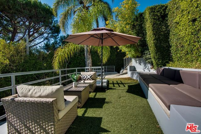 a view of a roof deck with couches and potted plants
