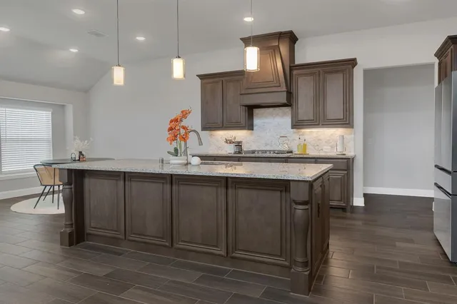 a kitchen with a sink cabinets and wooden floor