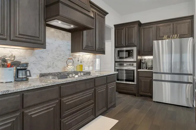 a kitchen with granite countertop stainless steel appliances and wooden cabinets