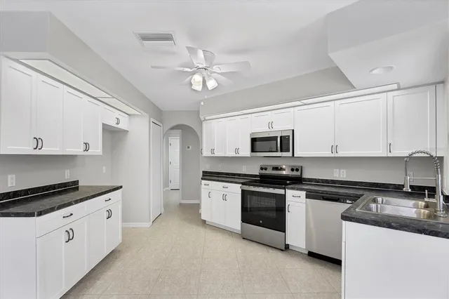 a kitchen with stainless steel appliances granite countertop a stove sink microwave and refrigerator