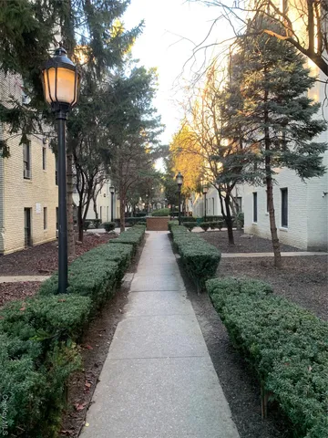 a front view of a house with a garden and trees