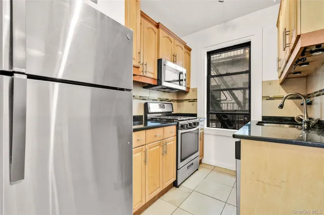 a kitchen with stainless steel appliances granite countertop a refrigerator sink and stove