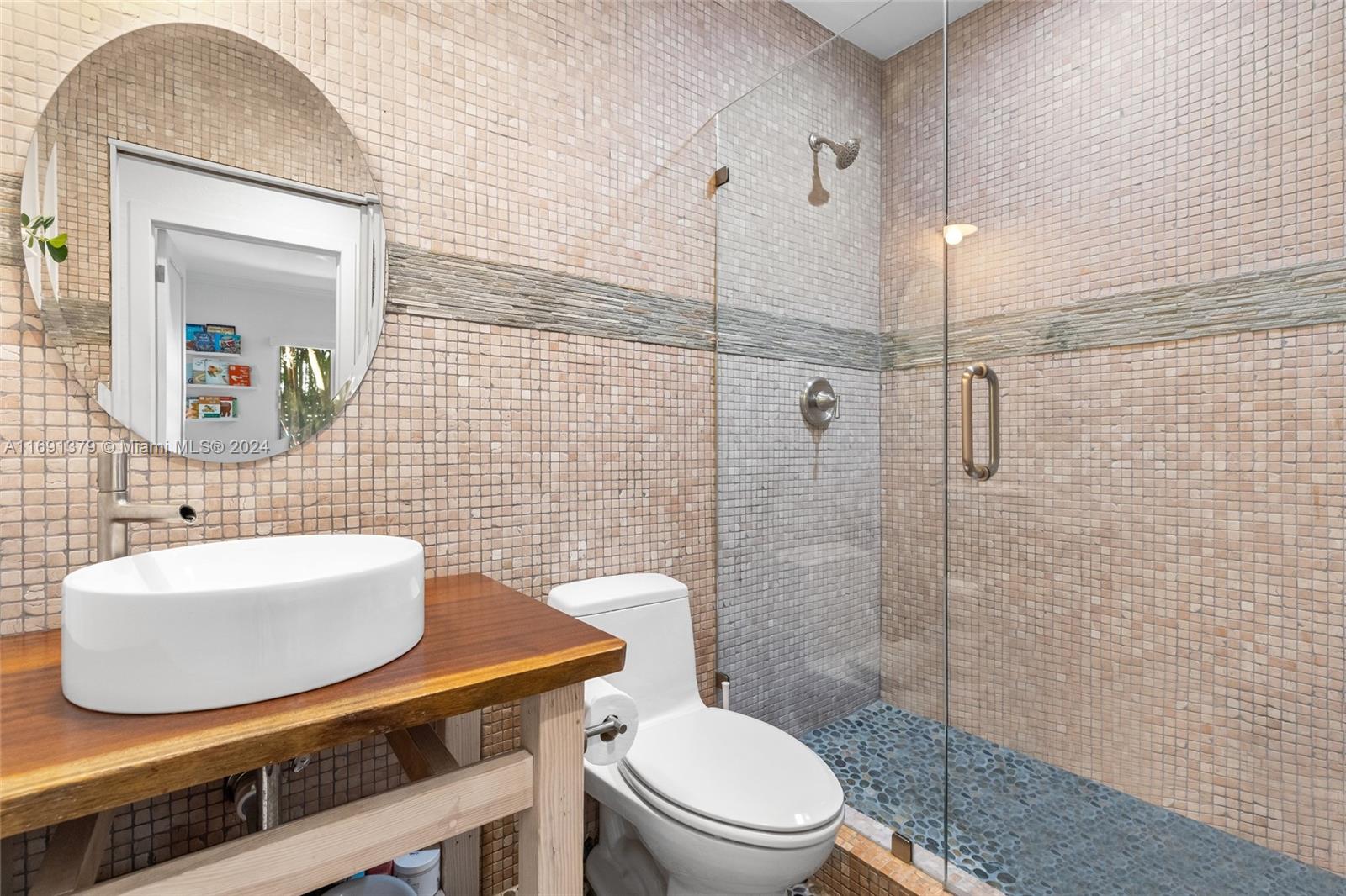 3685 St Gaudens Road Miami, FL 33133 - Photo 37 of 66 a bathroom with a toilet a sink and mirror