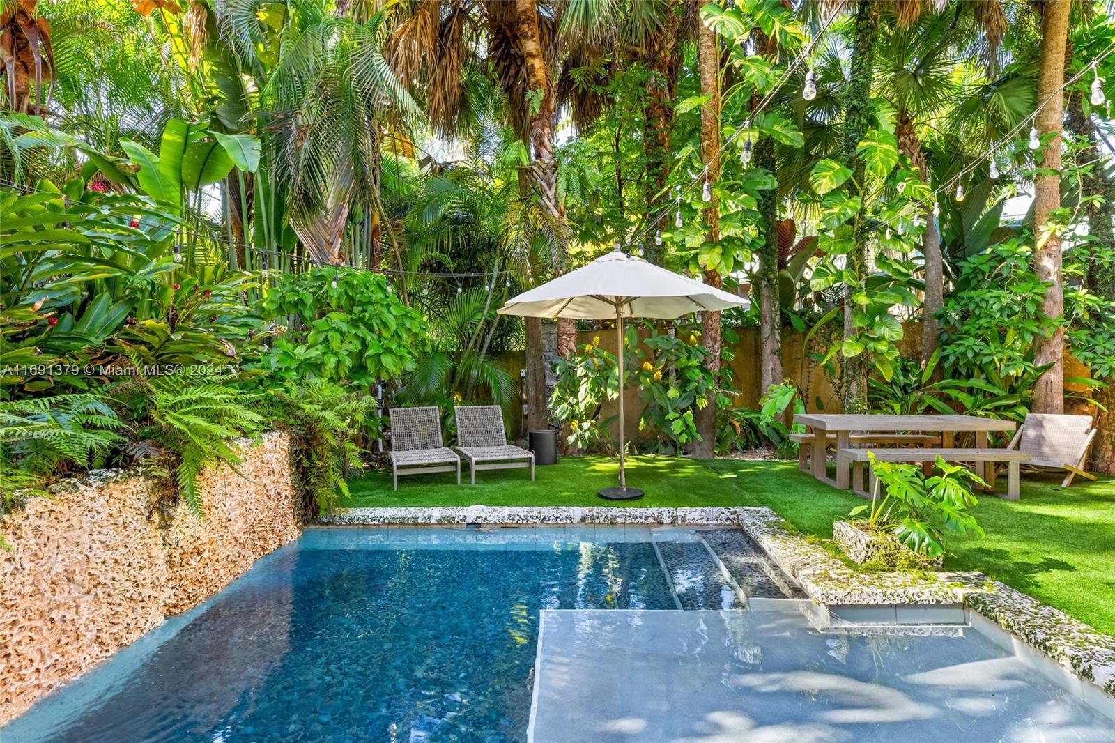 3685 St Gaudens Road Miami, FL 33133 - Photo 54 of 66 a view of a garden with a bench and plants