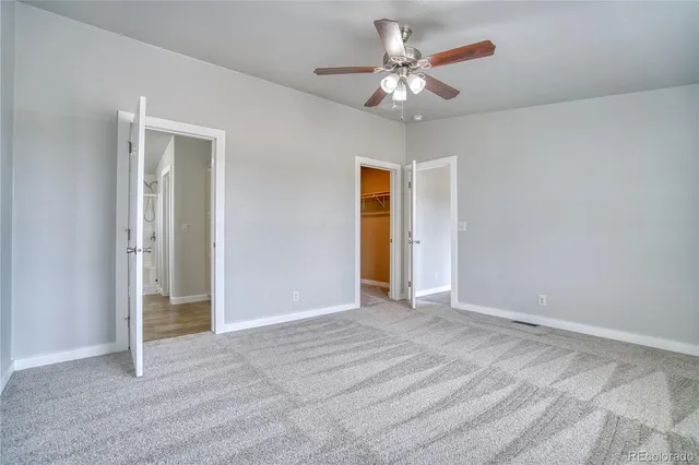 a view of an empty room with a chandelier fan