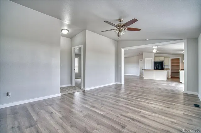 a view of a livingroom with wooden floor and a ceiling fan