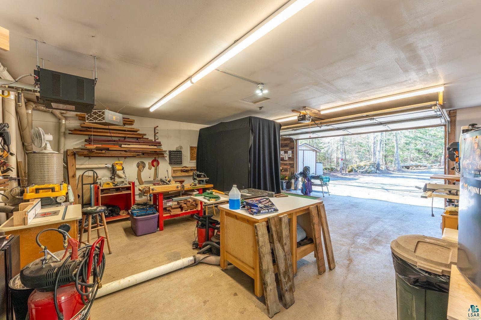 4452 Moccasin Point Road Tower, MN 55790 - Photo 34 of 44 Spacious garage with an overhead garage door, concrete flooring, and ample overhead lighting