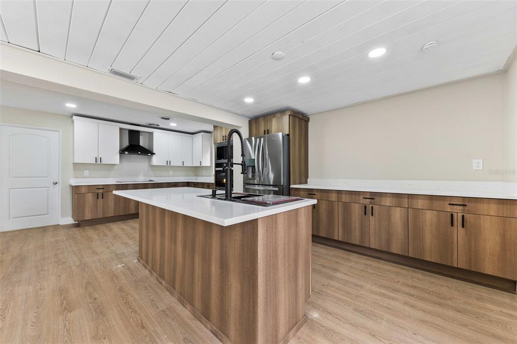 1822 Banyan Tree Drive Edgewater, FL 32132 - Photo 42 of 63 a large kitchen with stainless steel appliances a large counter top a sink a stove and a wooden floors