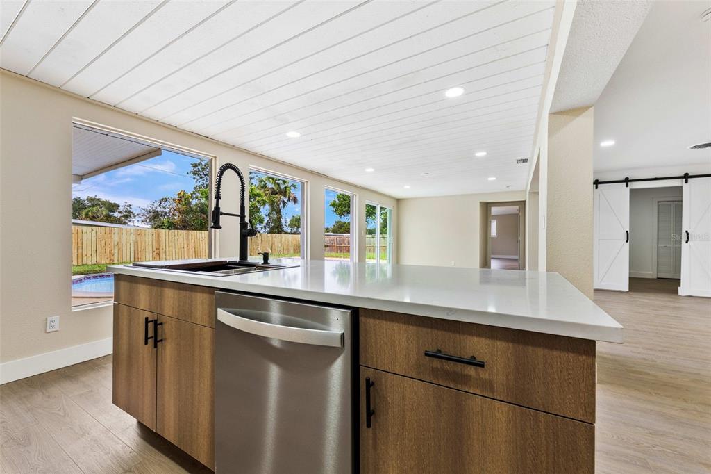 1822 Banyan Tree Drive Edgewater, FL 32132 - Photo 44 of 63 a kitchen with stainless steel appliances granite countertop a sink and wooden cabinets