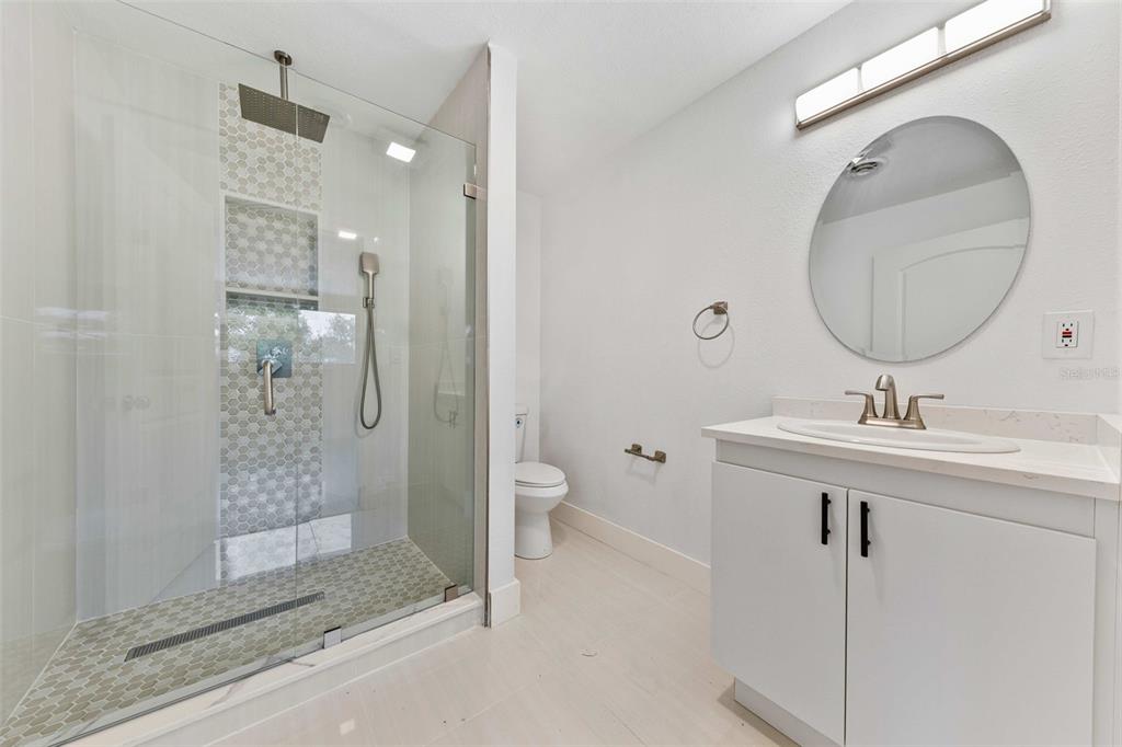 1822 Banyan Tree Drive Edgewater, FL 32132 - Photo 55 of 63 a bathroom with a shower sink vanity and mirror