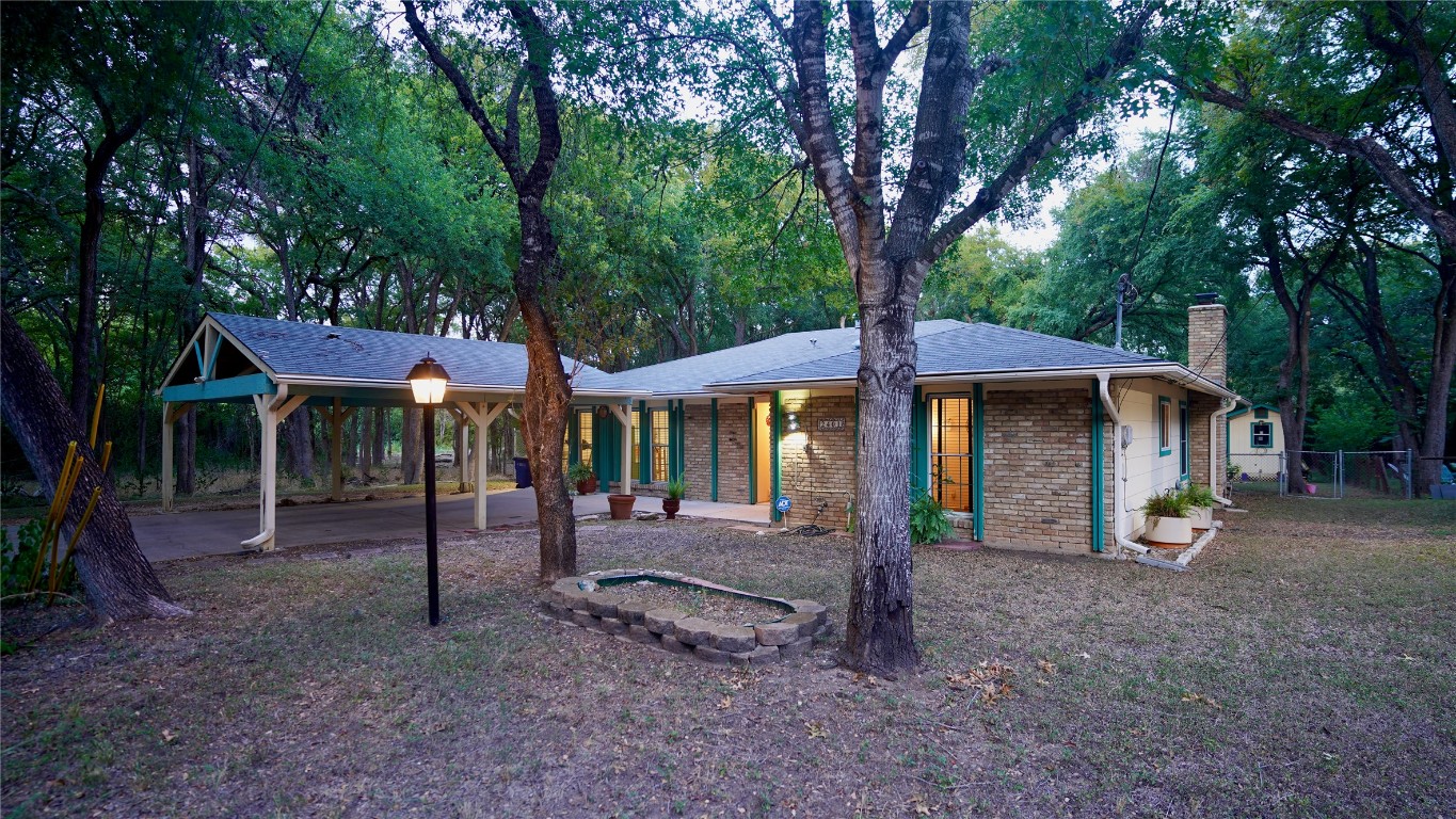 a view of a house with a backyard and a tree