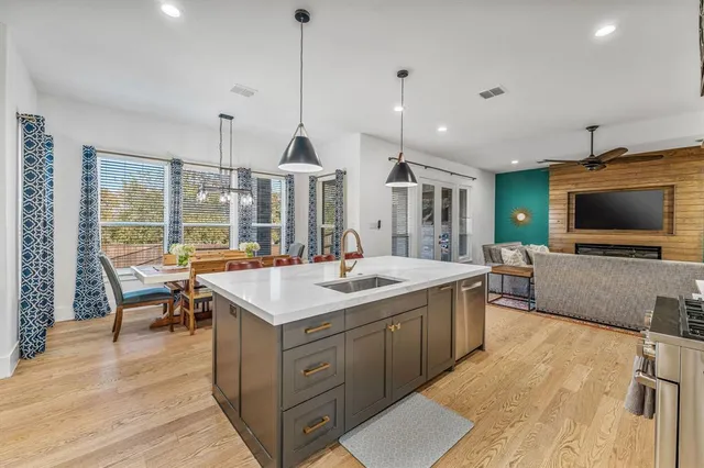 a kitchen with stainless steel appliances granite countertop a sink a stove and a wooden floors