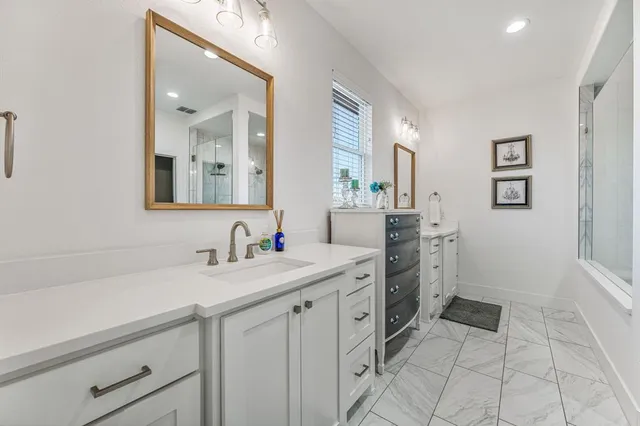 a spacious bathroom with a sink and a mirror