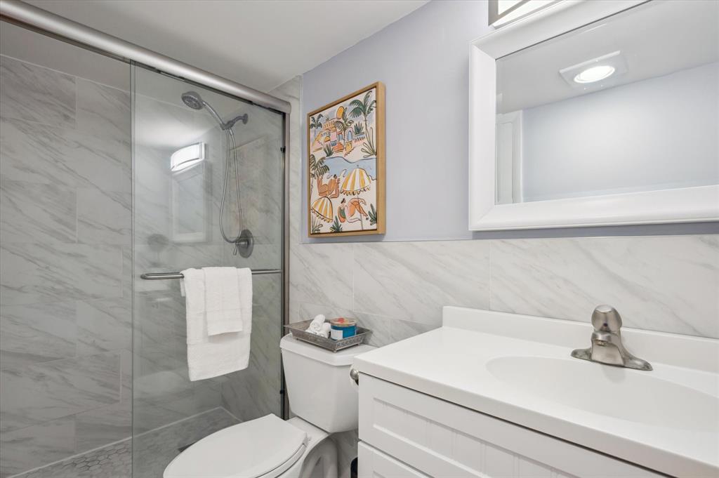 131 Southeast 3rd Avenue, Unit 302 Dania Beach, FL 33004 - Photo 12 of 16 a bathroom with a sink a toilet and a mirror