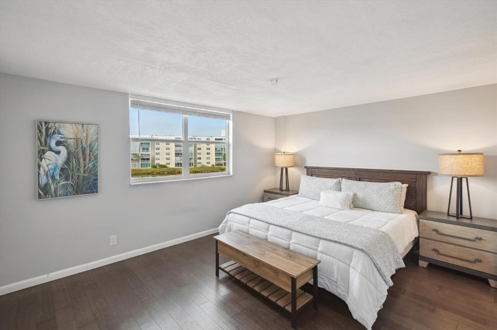 131 Southeast 3rd Avenue, Unit 302 Dania Beach, FL 33004 - Photo 10 of 16 a bedroom with a bed and a painting on the wall