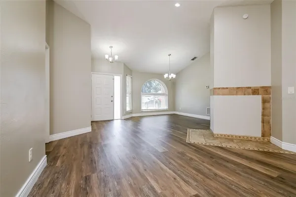 an empty room with wooden floor and window