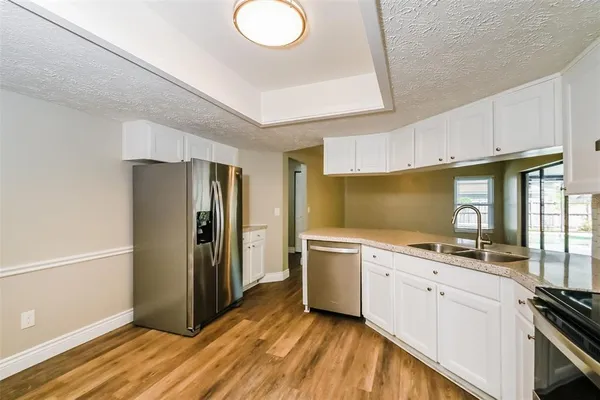 a kitchen with a sink appliances and cabinets