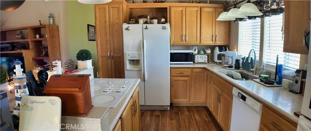 a kitchen with stainless steel appliances a refrigerator a sink and wooden floors