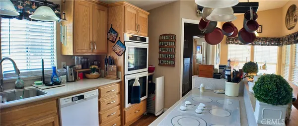 a kitchen with stainless steel appliances granite countertop a sink a stove and a wooden floor