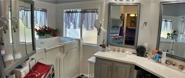 a bathroom with a sink vanity granite tub and shower