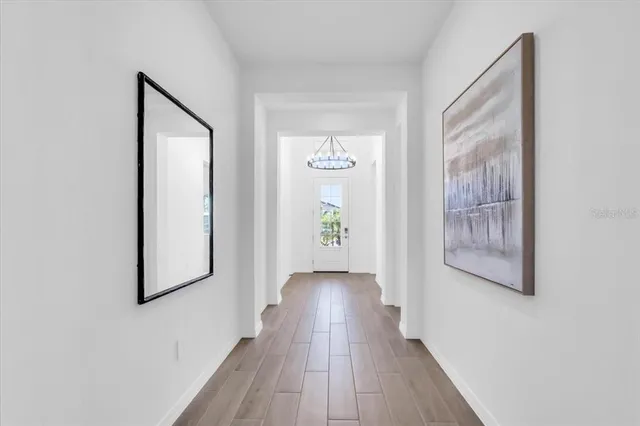 a view of a hallway with wooden floor and closet