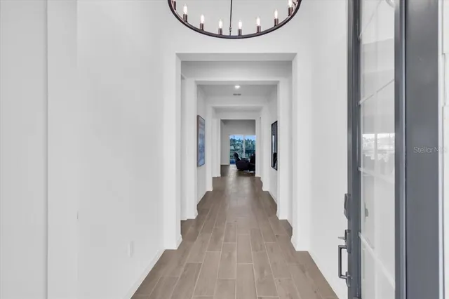 a view of a hallway with wooden floor and a mirror