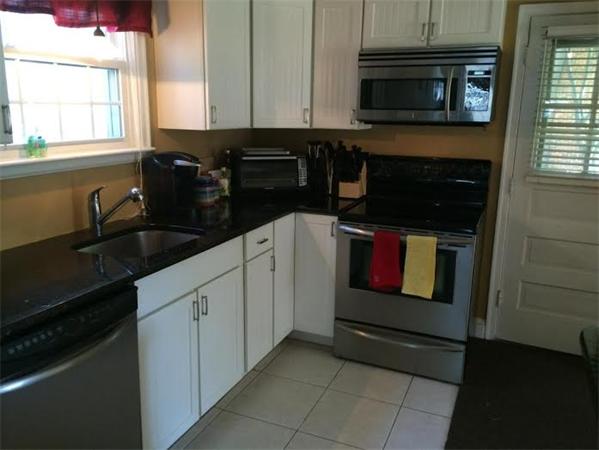 1562 Plumtree Road Springfield, MA 01119 - Photo 5 of 21 a kitchen with granite countertop white cabinets and black appliances