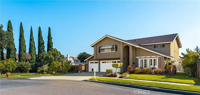 a view of a house with a big yard and large trees