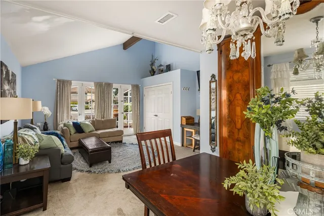 a living room with furniture flowerpot and a chandelier