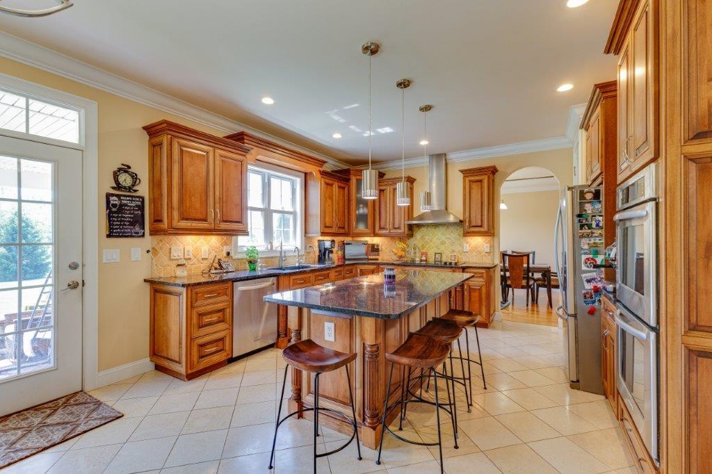 61 Bridgewater Road Bridgewater, VA 22812 - Photo 6 of 75 a kitchen with stainless steel appliances granite countertop a stove top oven a sink a dining table and chairs with wooden floor