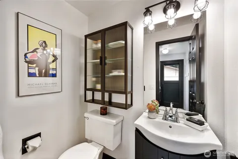 a bathroom with a toilet a sink and mirror
