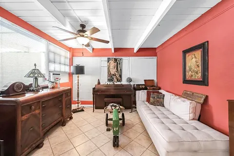 a living room with furniture a chandelier and a piano