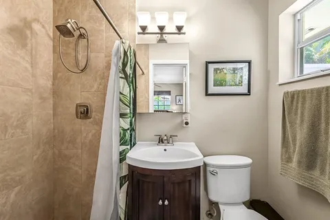 a bathroom with a sink a toilet and shower