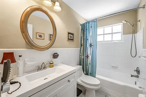 a bathroom with a sink a mirror a toilet and a shower