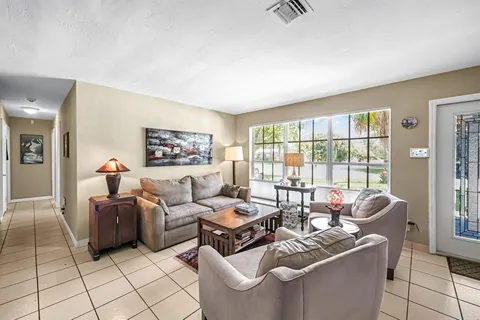 a living room with furniture and a floor to ceiling window
