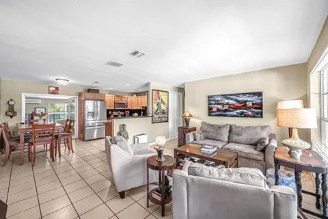 a living room with furniture and a dining table with kitchen view