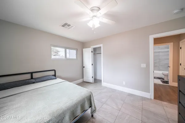 a bedroom with a large bed and a chandelier