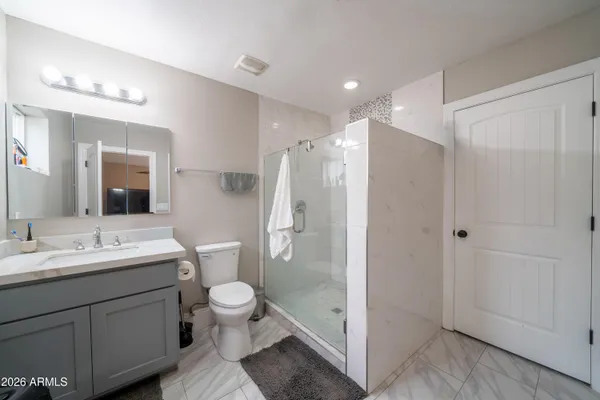 a bathroom with a toilet a sink and mirror