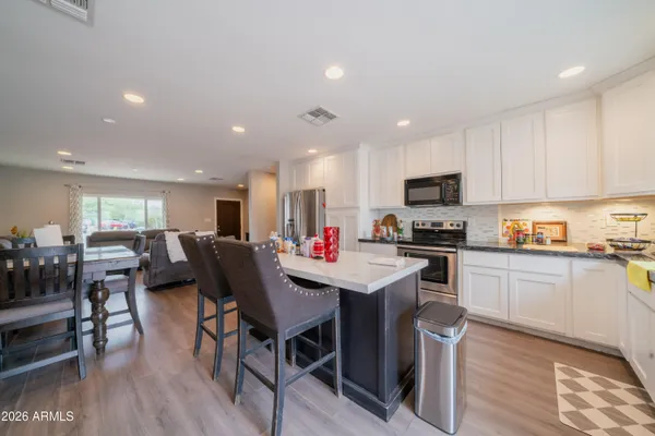 a kitchen with a dining table chairs stainless steel appliances and cabinets
